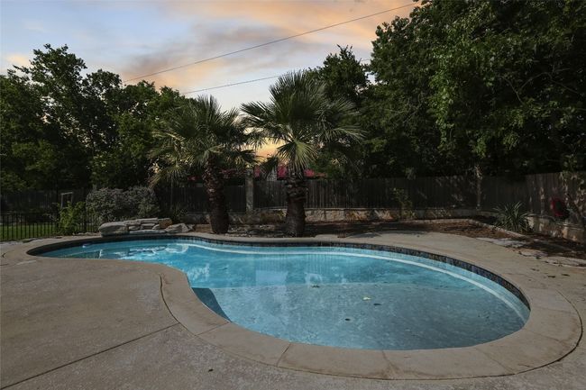 View of swimming pool with a fenced backyard | Image 17