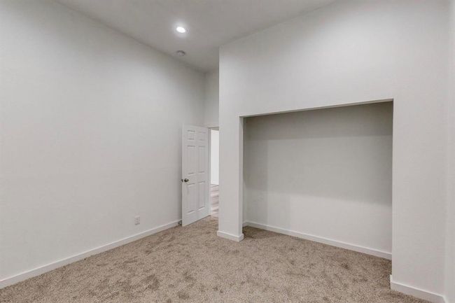 Unfurnished bedroom with carpet flooring and a high ceiling | Image 29