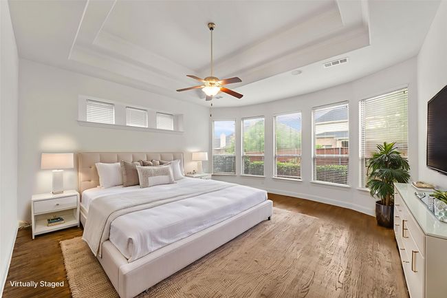 Bedroom featuring a raised ceiling, wood finished floors, ceiling fan, and ornamental molding | Image 18