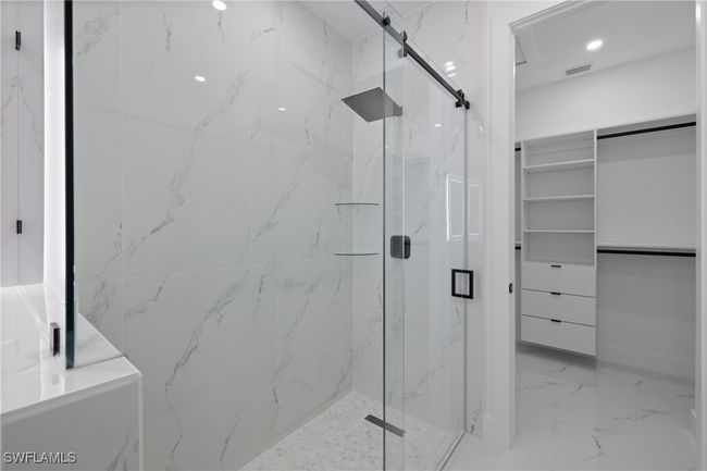 Full bath with a marble finish shower, marble tiled floors, a spacious closet, and recessed lighting | Image 24