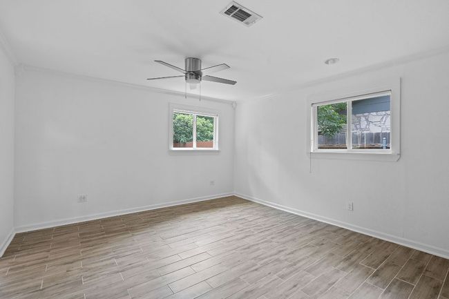 Primary bedroom features view to private backyard. | Image 17