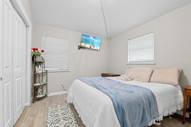 Bedroom with light wood-type flooring, a closet, baseboards, and vaulted ceiling | Image 18