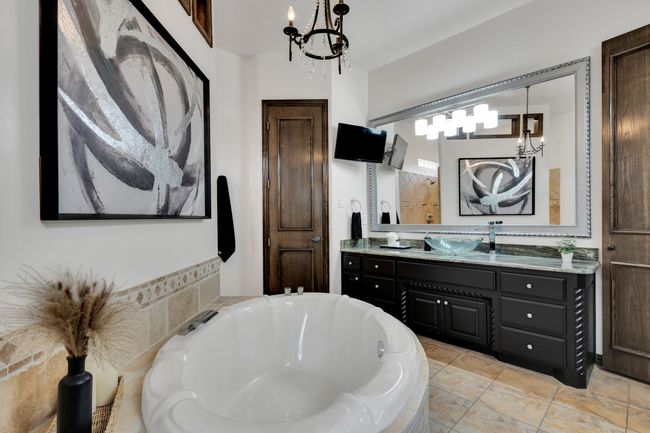 Full bathroom with a garden tub, vanity, and and chandelier | Image 19