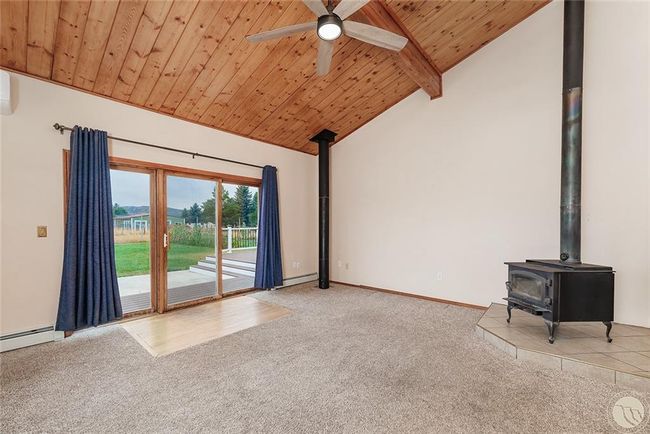 Living room with patio door to back deck and wood stove. | Image 10