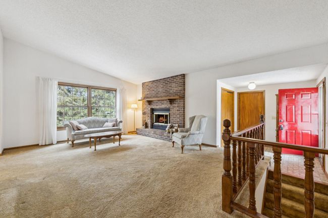 Spacious main level living room with a floor to ceiling brick fireplace | Image 4
