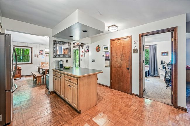 Bright kitchen featuring a functional island, open to the dining area. | Image 18