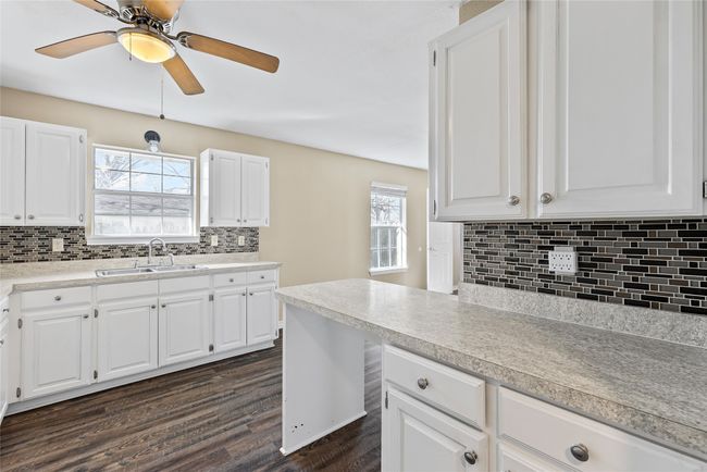 Kitchen featuring light countertops, dark wood-style flooring, a sink, and a wealth of natural light | Image 32