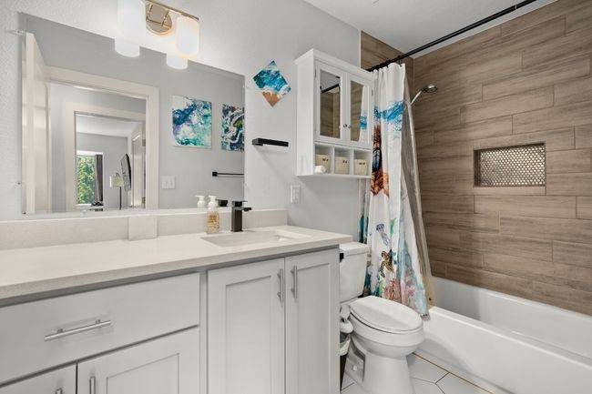 Full bath upstairs with large vanity, shower / tub combo with curtain, and tile patterned floors | Image 19