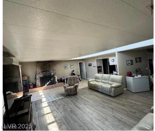 Living area with a fireplace and wood finished floors | Image 4