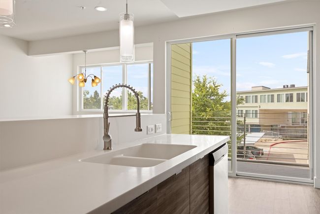 Kitchen featuring light countertops, modern cabinets, pendant lighting, recessed lighting, and dishwashing machine | Image 11