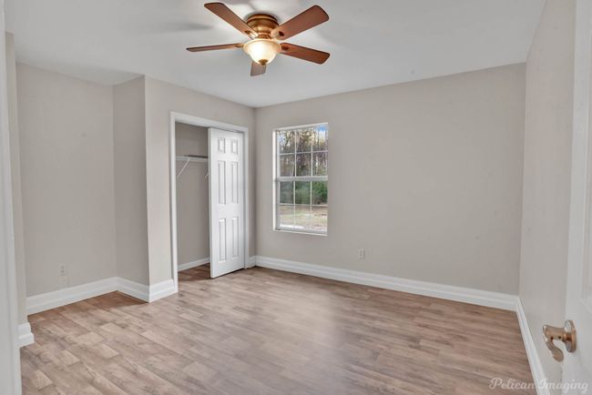 Unfurnished bedroom featuring a closet, light hardwood / wood-style flooring, and ceiling fan | Image 15
