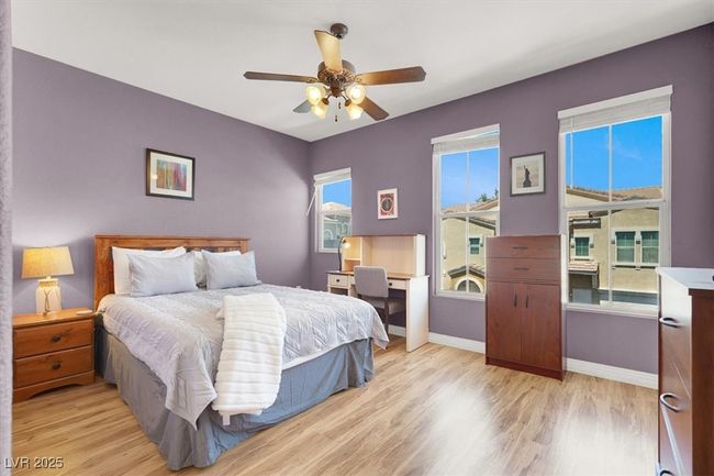 Bedroom featuring a ceiling fan, light wood-style flooring, and baseboards | Image 26