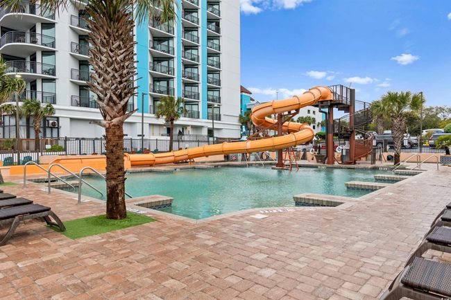 Community pool featuring a water slide and a patio | Image 29