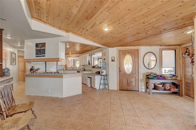 Entrance foyer featuring wooden ceiling, light tile patterned flooring, vaulted ceiling, and recessed lighting | Image 26