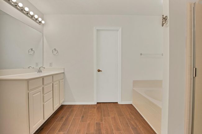 Bathroom featuring vanity, a bath, and wood finished floors | Image 14
