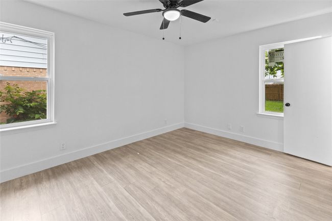 Empty room featuring light wood-style flooring, a ceiling fan, and baseboards | Image 17