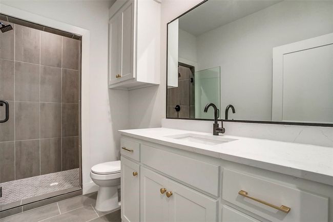Full bathroom with toilet, vanity, a stall shower, and tile patterned floors | Image 30