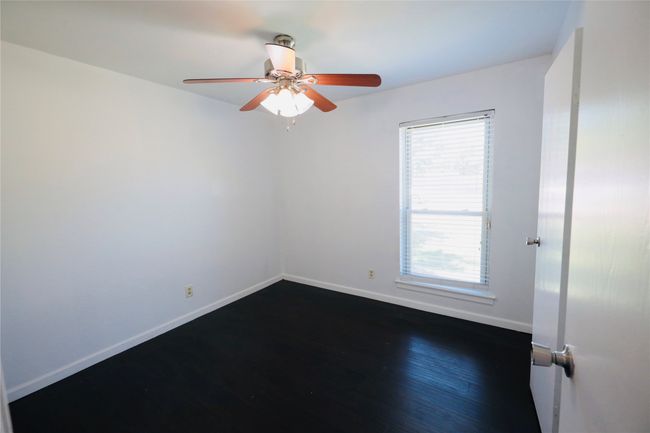 Bedroom with dark wood finished floors and ceiling fan | Image 23
