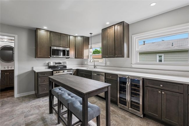 Indluded appliance package offers an electric stove, refrigerator, wine fridge, dishwasher, and garbage disposal. | Image 4