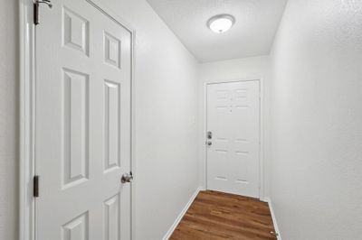 Doorway featuring a textured ceiling and dark hardwood / wood-style floors | Image 3