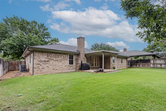 Back of house featuring brick siding, a chimney, a patio, and a fenced backyard | Image 29