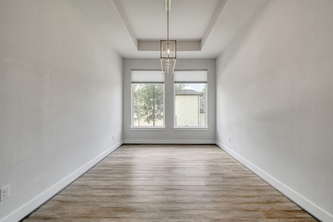Unfurnished room featuring a raised ceiling and wood finished floors | Image 9