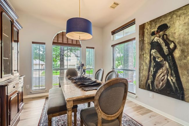 Dining area with custom chandelier & wood-style flooring and baseboards | Image 6