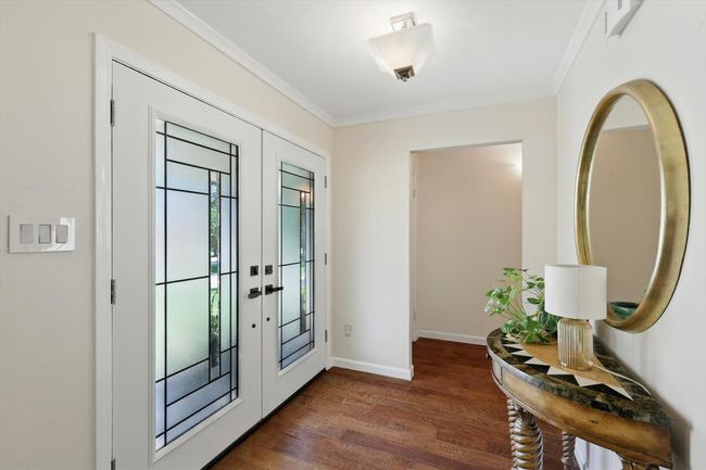 Entrance foyer with french doors, crown molding, and dark wood-type flooring | Image 5