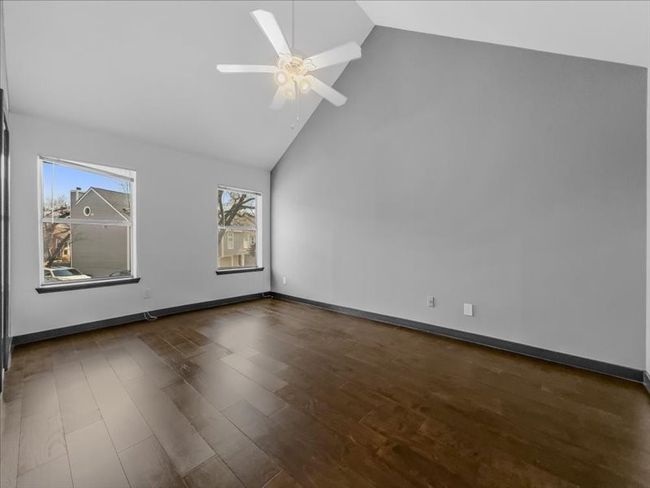 Upstairs bedroom featuring ceiling fan, dark hardwood / wood-style floors, and high vaulted ceiling | Image 18