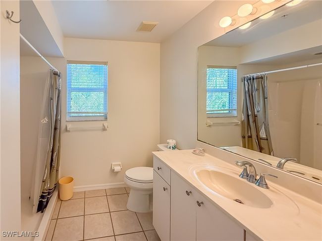 Bathroom with toilet, vanity, baseboards, visible vents, and tile patterned floors | Image 35