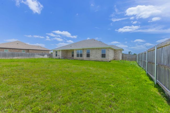 Rear view of house with a fenced backyard and brick siding | Image 24