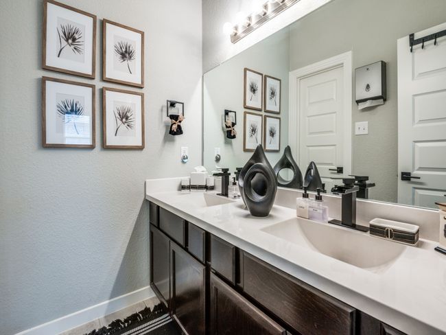 Bathroom with baseboards, a textured wall, a sink, and double vanity | Image 26