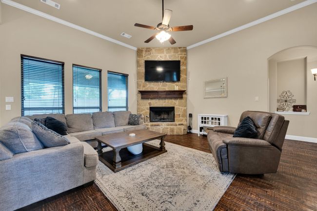 Living room featuring ornamental molding, baseboards, arched walkways, ceiling fan, and plenty of natural light | Image 14