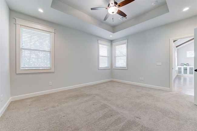 Large primary suite with tray ceiling and plenty of light. | Image 13