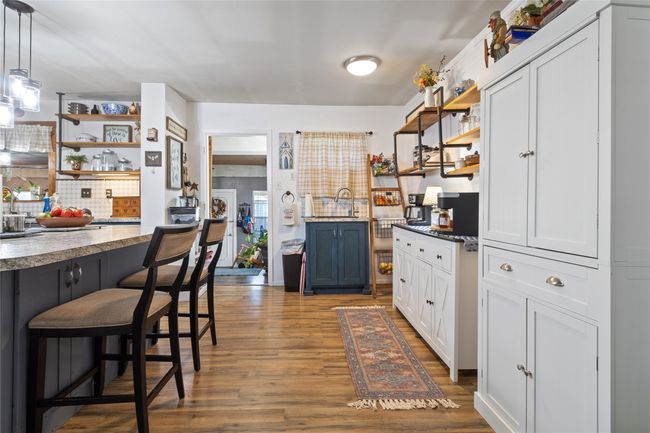 Kitchen featuring open shelves, wood finished floors, and backsplash | Image 8
