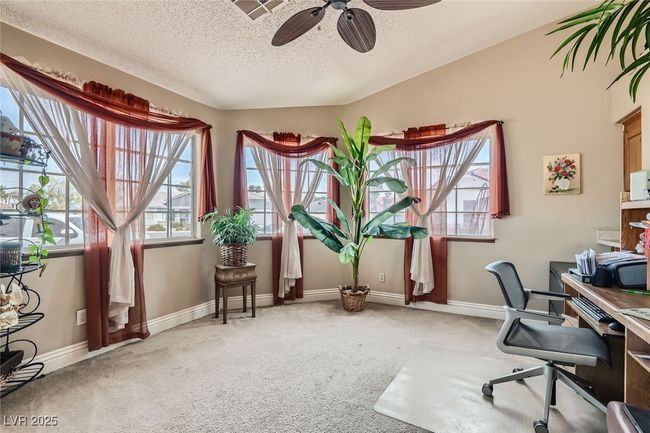 Carpeted office space featuring ceiling fan, visible vents, baseboards, and a textured ceiling | Image 5