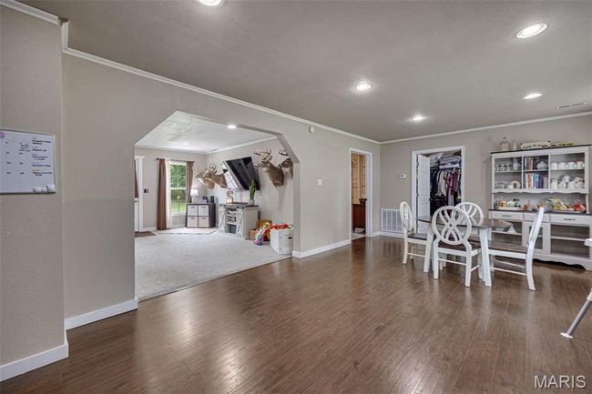 Dining area featuring ornamental molding, arched walkways, wood finished floors, recessed lighting, and baseboards | Image 5