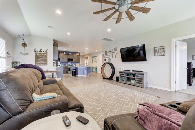 Living area featuring a ceiling fan, light wood-type flooring, recessed lighting, and lofted ceiling | Image 8