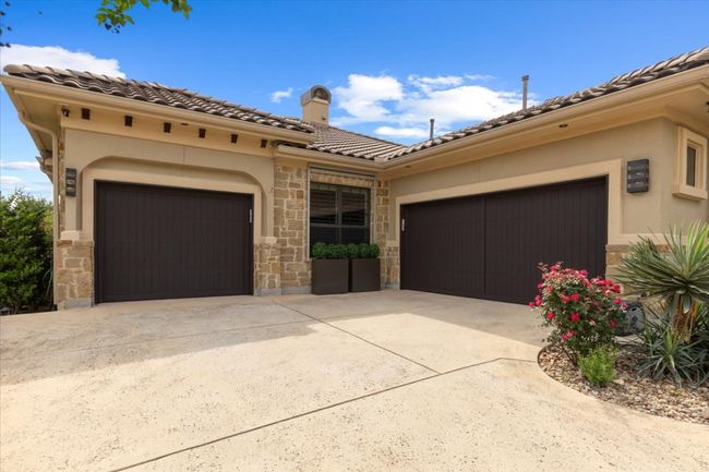 Mediterranean / spanish-style house featuring an attached garage, driveway, stone siding, and stucco siding | Image 32