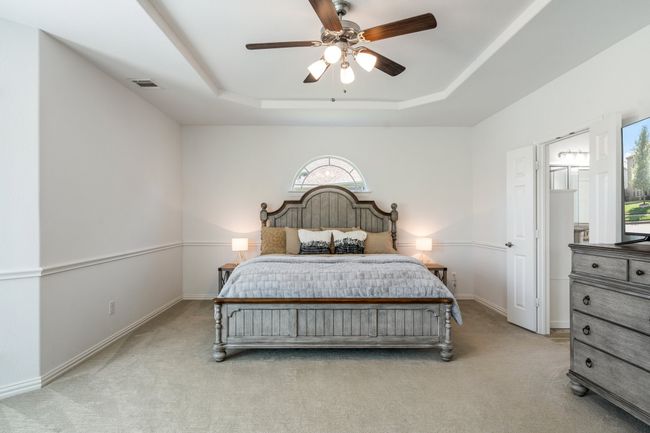 Bedroom with light carpet, a raised ceiling, and a ceiling fan | Image 20