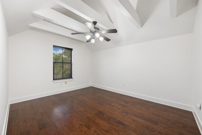 A spacious guest room with vaulted ceilings and a ceiling fan. | Image 29