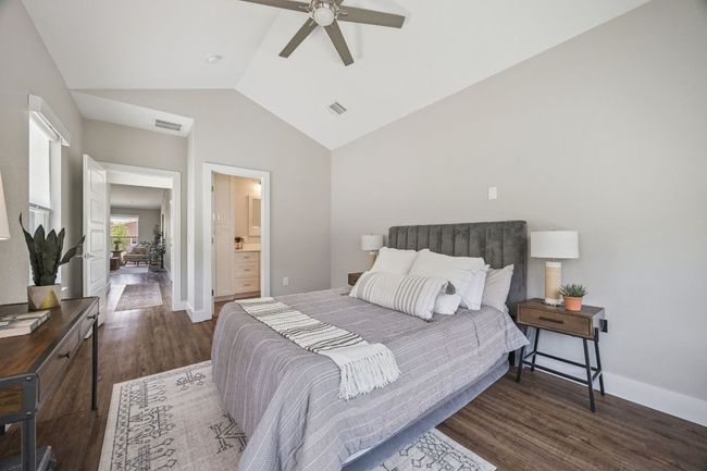 Bedroom featuring lofted ceiling, wood finished floors, ceiling fan, and connected bathroom | Image 19