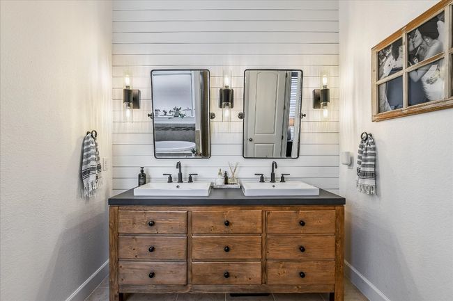 Bathroom with wood walls, double vanity, a sink, and baseboards | Image 19