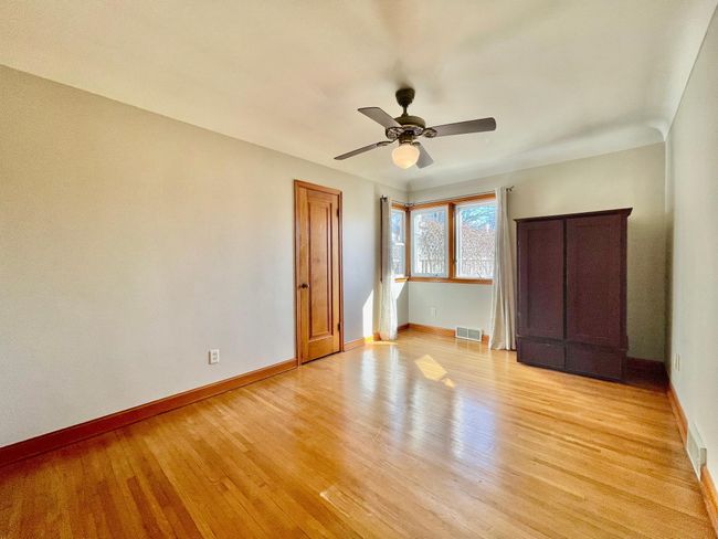 The primary bedroom has room for a reading corner near the windows and features the same beautiful hardwood floors and doors. | Image 13