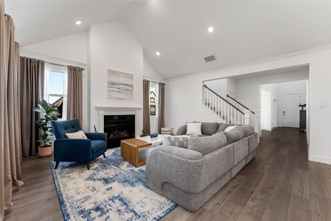 Living area featuring stairway, healthy amount of natural light, wood-type flooring, recessed lighting, and high vaulted ceiling | Image 21