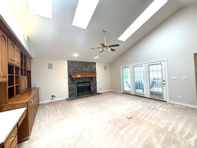 Great room with vaulted ceilings, sky lights, ceiling fan, gas fireplace and built-in cabinets. | Image 7