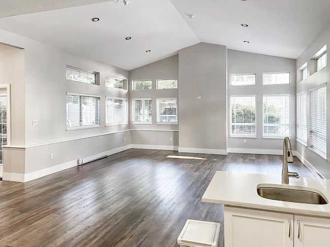 Living room featuring dark wood-style flooring, high vaulted ceiling, baseboards, a baseboard heating unit, and recessed lighting | Image 13