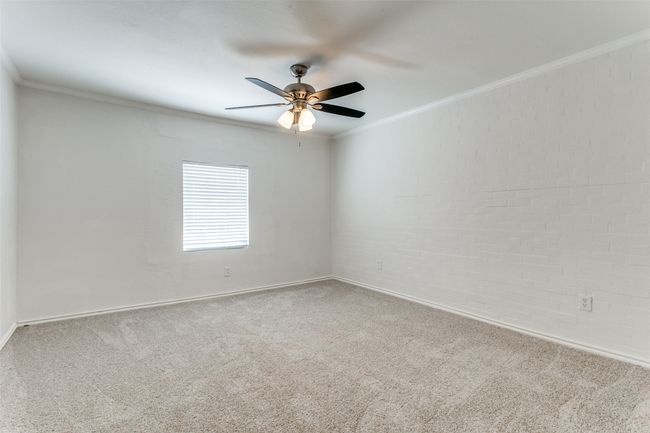Carpeted spare room featuring baseboards, a ceiling fan, and crown molding | Image 15