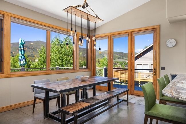 Dining area featuring finished concrete flooring, a mountain view, and lofted ceiling | Image 5