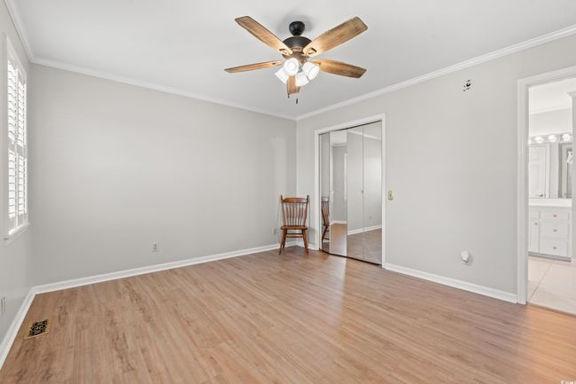 Unfurnished bedroom with multiple windows, light wood-type flooring, ornamental molding, and a closet | Image 32